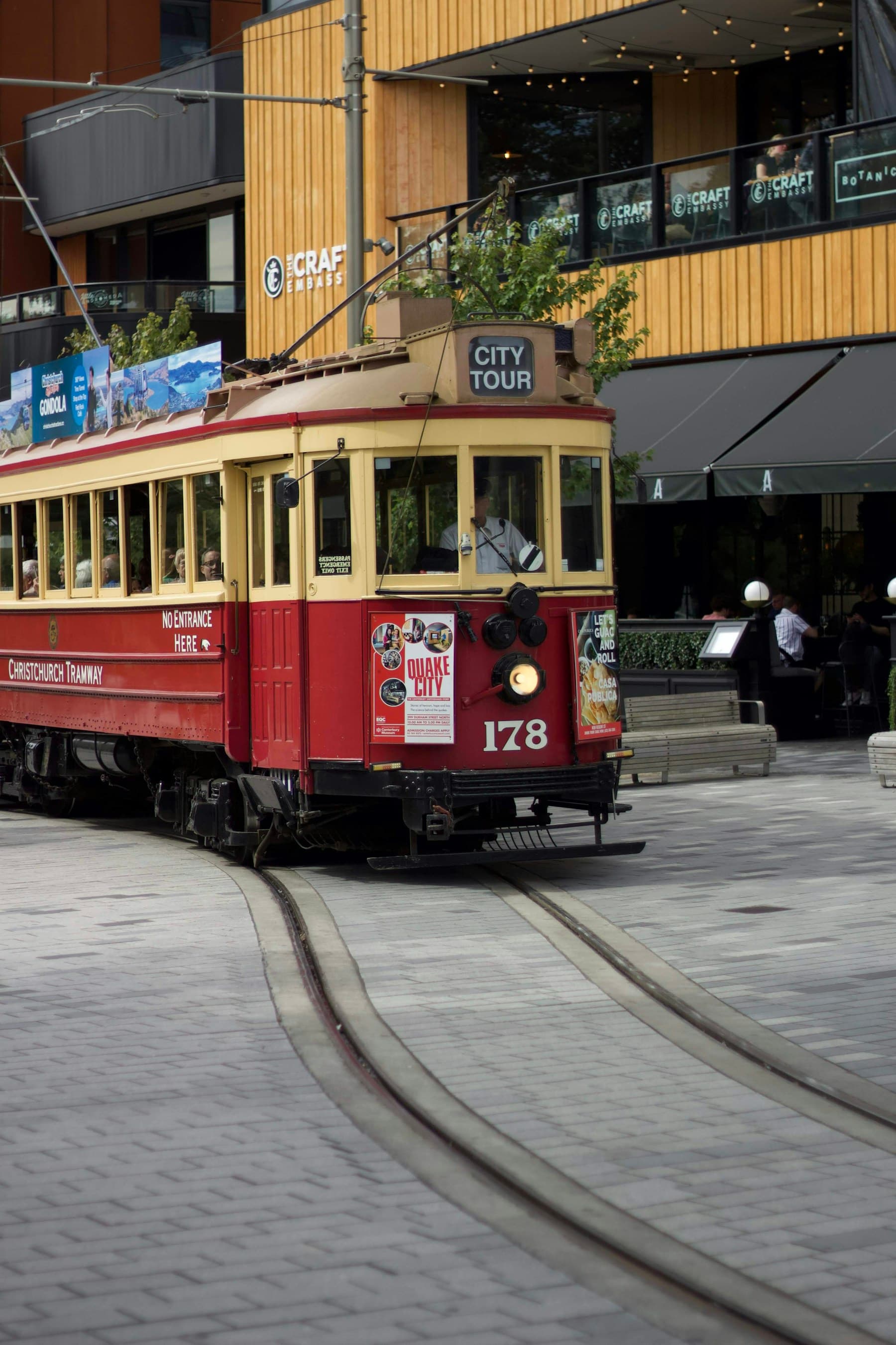 A red and cream heritage tram travelling through central Christchurch