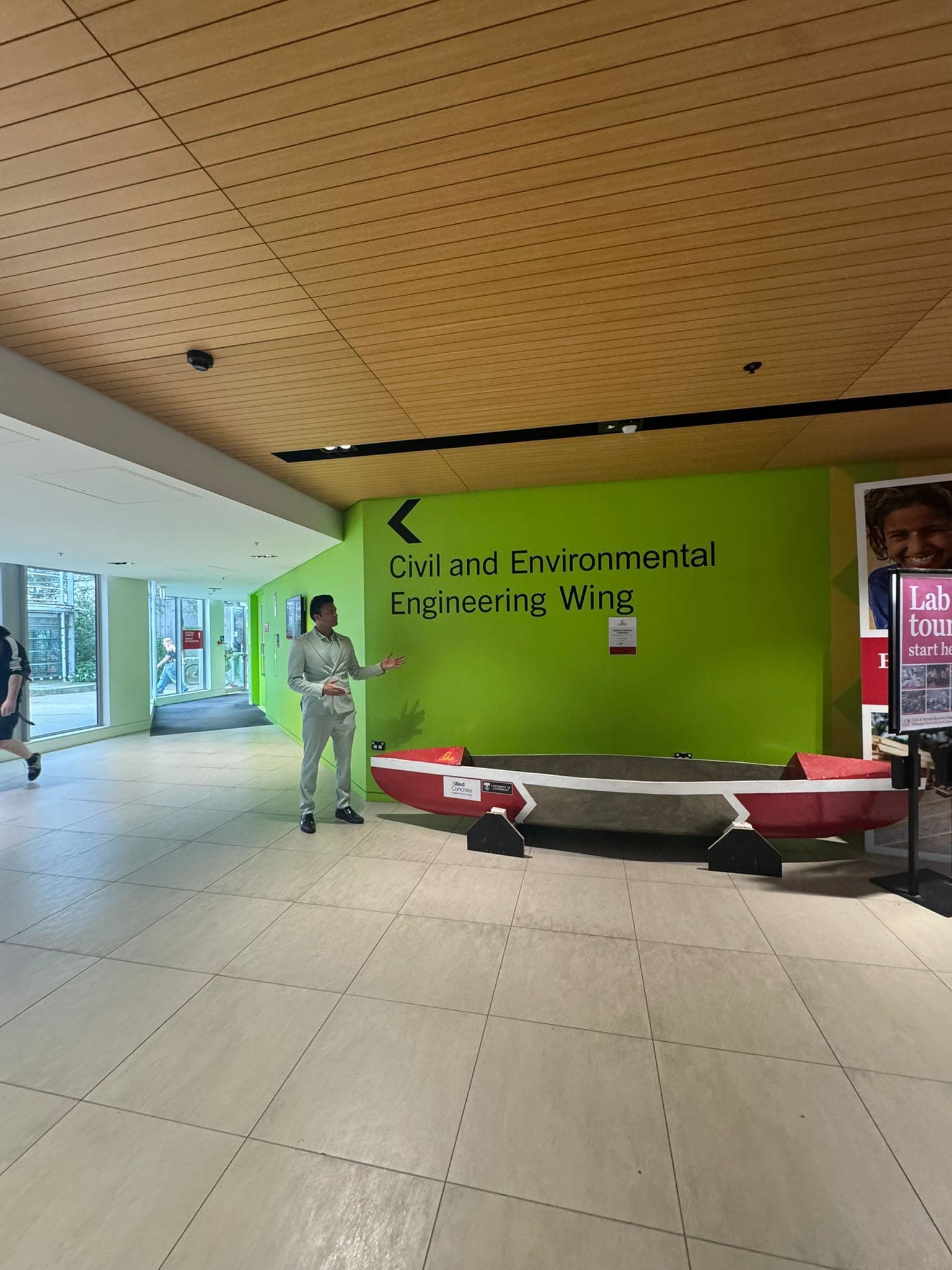 A visitor inside the Civil and Environmental Engineering Wing beside a canoe display